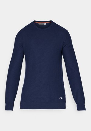 Sweater de gola redonda azul marinho, feito de material tricotado, com mangas longas e um pequeno logótipo na parte inferior direita da frente.