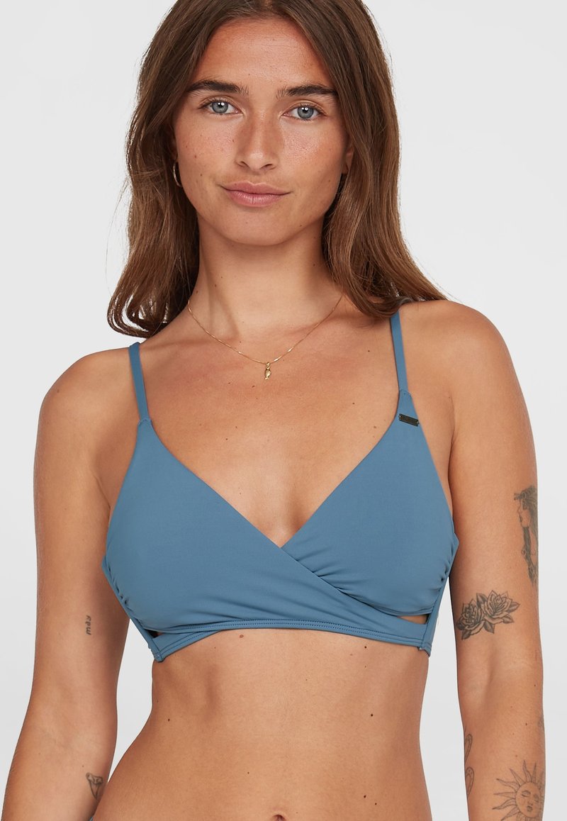 Top bikini triangolo azzurro chiaro con spalline sottili e design incrociato. Il tessuto è liscio, con ritagli laterali e minimi dettagli in metallo.