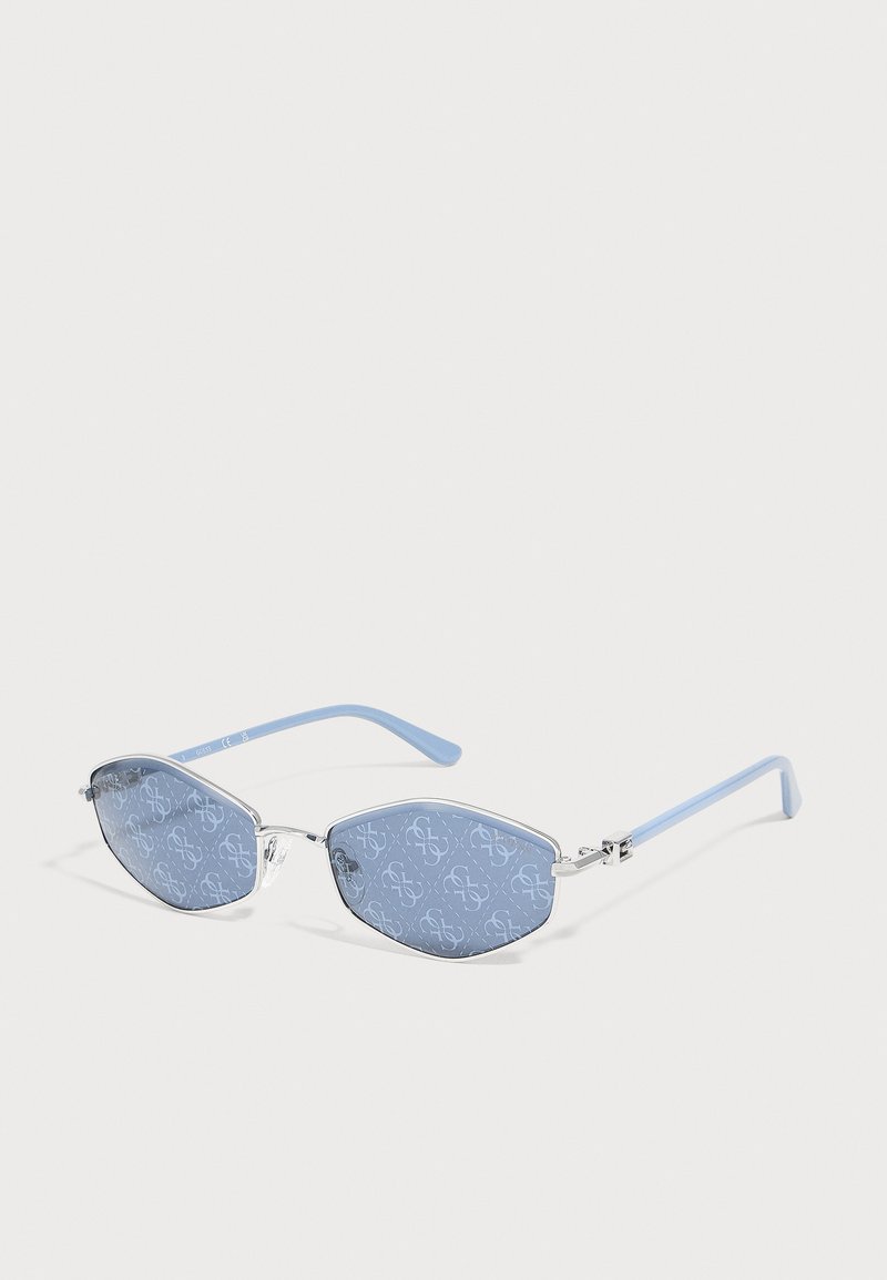 Lunettes de soleil à monture argentée avec verres à motifs bleu clair et branches bleu clair sur fond blanc.