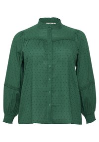 Groene blouse met een hoge kraag, gestructureerde stof, verticale strepen en kleine stippen. Heeft een knoopsluiting en kantaccenten.