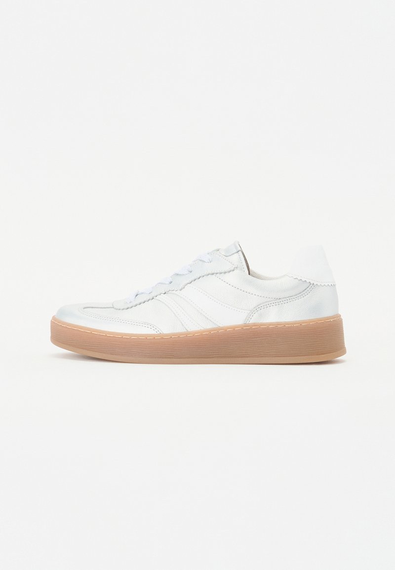 Sneaker bianco in pelle con texture liscia, punta rotonda, chiusura con lacci e tre strisce laterali; la suola in gomma beige crea un contrasto.