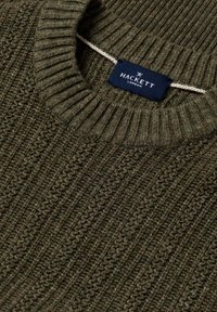 Maglione verde oliva a maglia con texture a coste e collo a girocollo. Presenta un'etichetta con la scritta "HACKETT LONDON" in bianco su sfondo blu.