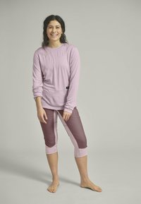 Light lavender long-sleeve top paired with maroon and pink capri leggings. Soft fabric, fitted design, and contrasting color block patterns.