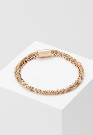 Roségouden armband met meerdere schakels en een gladde cilindrische magnetische sluiting, tentoongesteld op een wit voetstuk.