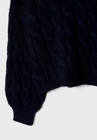 Maglione lavorato a maglia di colore blu navy con un motivo a treccia testurizzato, polsini e orlo a coste. Il tessuto sembra morbido e spesso.