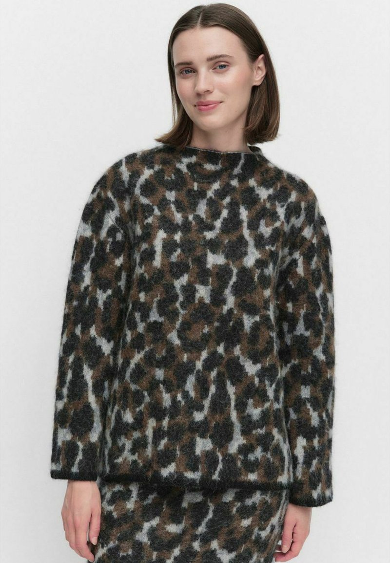 Leopardskinnetröja i mjukt, fluffigt material med rund halsringning och sänkta axlar. Dominerande färger är grå, svart och brun.