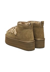 Pruunist sametist platvormsisetootel on paksud kummist tallad, beežid nöörid ja pehme karusnahk sees.