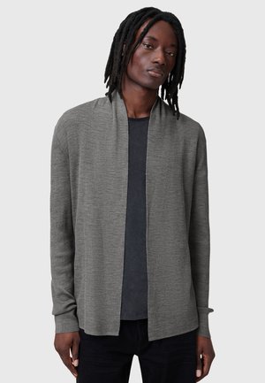 Cardigan grigio aperto davanti con texture a costine, maniche lunghe e vestibilità comoda, indossato sopra una t-shirt scura, su uno sfondo neutro.