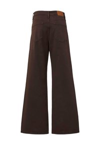 Dunkelbraune weit geschnittene Hose mit Gesäßtaschen und einem Leder-Logo-Patch am Bund, von hinten gezeigt.
