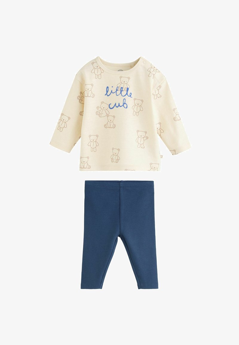 Chemise bébé crème à manches longues avec imprimés d'ours brun et texte "petit ourson" associée à des leggings bébé bleu unis.