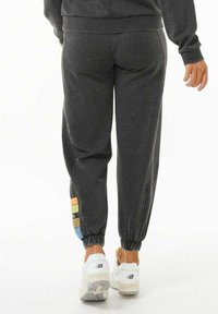 Grå sweatpants med en tapered ben, elastiske manchetter, med farverige side accenter i orange, gul og blå. Blød stofstruktur.