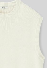 Top en tricot sans manches beige clair avec un col rond, présentant une texture côtelée et des détails autour des emmanchures et du col.