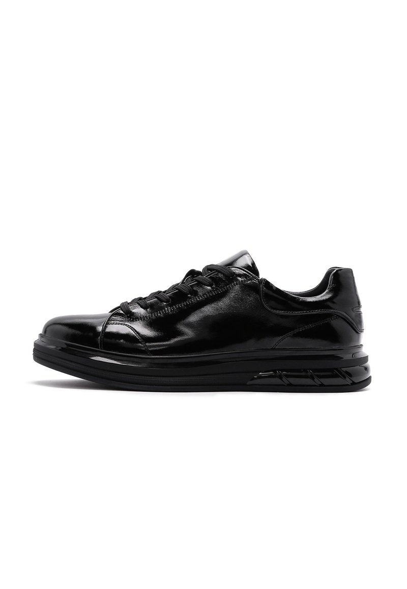 Zapatilla deportiva negra con acabado brillante, puntera redondeada, diseño con cordones, suela acolchada y un patrón de relieve distintivo para un mejor agarre.