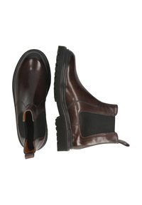 Botas Chelsea de cuero marrón con paneles laterales elásticos negros y suelas de goma negra gruesas, mostradas desde vistas superior y lateral sobre un fondo blanco.