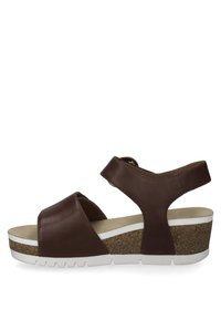 Hnědé kožené sandály na wedge s dvěma širokými popruhy, nastavitelným zadním popruhem a strukturální korkovou podrážkou. Bílé akcenty na mezipodrážce.