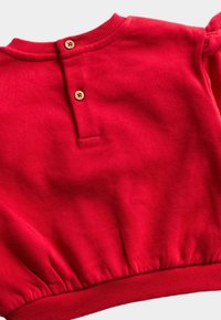 Roter Baumwollpullover mit geripptem Ausschnitt, puffärmel und durch Knöpfe verschlossenem Schlitz auf der Rückseite, mit gerafftem Saumdetail.