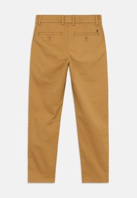 Khaki chinos, cotton fabric, slim fit, five-pocket design with two back pockets, double belt loops, subtle brand tab on the rear.