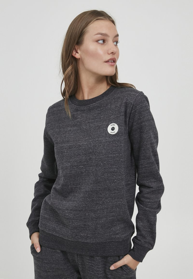 Dunkelgrauer Sweatshirt mit langen Ärmeln, rundem Ausschnitt und strukturierter Stoffzusammensetzung. Enthält ein rundes Logo-Patch auf der Brust.