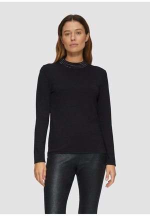 Zwart longsleeve top met hoge nek en een textuurrijke, versierde kraag. Zachte stof en aansluitend ontwerp. Gecombineerd met glanzende zwarte leggings.