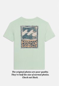 Világoszöld rövid ujjú póló hátulján téglalap alakú, stilizált hullámokat ábrázoló grafika kék és barack színekben, valamint "BILLABONG" felirat.