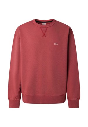Raudonas džemperis su ribotu rankogaliu ir apačia, turintis tekstūruotą paviršių. „PJL“ logotipas siuvinėtas baltos spalvos ant krūtinės. Apvalus kaklo iškirpimas.
