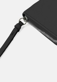 Portafoglio in pelle nera con chiusura a zip, finitura testurizzata e una tracolla staccabile fissata a un anello metallico.