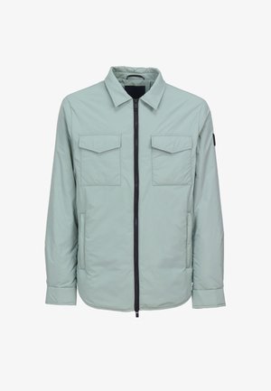 Veste matelassée vert clair avec col, fermeture éclair frontale, deux poches à rabat sur la poitrine et poches latérales, présentée sur un fond blanc.