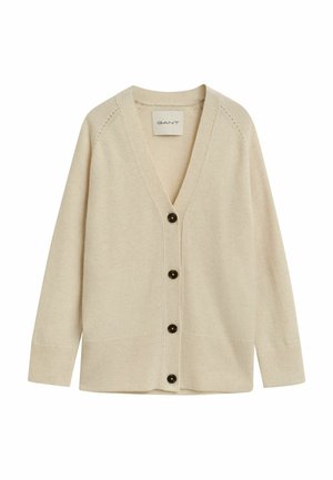 Beige kardigan med V-hals, lange ermer og frontknapper. Har ribbestrikkede mansjetter og kant, laget av mykt strikket stoff.