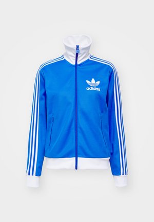 Niebieska kurtka dresowa na zamek, wykonana z gładkiego poliestru, z białymi akcentami, wysokim kołnierzem i trzema białymi paskami na każdym rękawie.