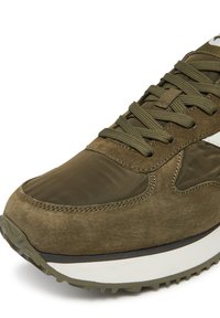 Olivzaļas krāsas sporta apavi ar zamšāda un neilona augšdaļu, teksturētu virsmu, apaļu purngalu un biezu melnas gumijas zolīti ar baltu akcentu.