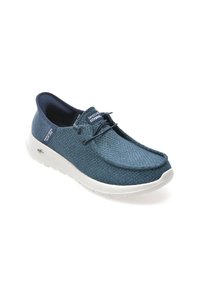 Scarpa in tessuto blu con texture, punta arrotondata, suola bianca e design con lacci. Presenta un logo sulla linguetta e sul lato.