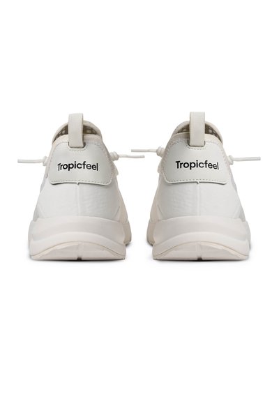 Paire de baskets blanches Tropicfeel vues de dos, avec des boucles de traction et des semelles épaisses et rembourrées sur un fond blanc.