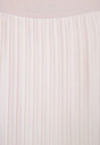 Plisserad kjol i ljusrosa tyg, med vertikala veck och en slät midja. Texturerad yta med ett mjukt, flödande utseende.
