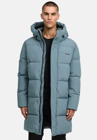 Light blue puffer jacket with a hood, featuring a zip front, side pockets, and a text logo detail. The fabric has a smooth, matte finish.