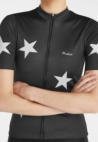 Maillot de cyclisme noir à manches courtes, avec de grands motifs d'étoiles blanches, une fermeture éclair à l'avant et un petit logo "Protest" sur la poitrine.