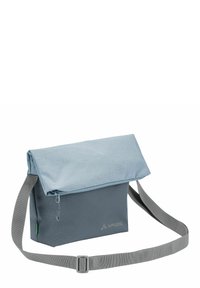 Borsa a tracolla in blu tenue, realizzata in tessuto resistente. Presenta una chiusura a pattina, una tracolla grigia regolabile e una tasca con zip. Logo VAUDE ben visibile.