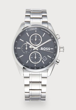 Silver stainless steel wristwatch with black dial, three subdials, tachymeter scale, date window at 4 o'clock, and "BOSS" logo on face.