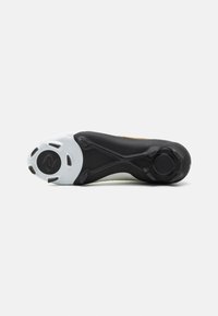 Suola di scarpa sportiva, con un'esterno nero, suola in gomma bianca, superficie texture e un accento arancione di lato.