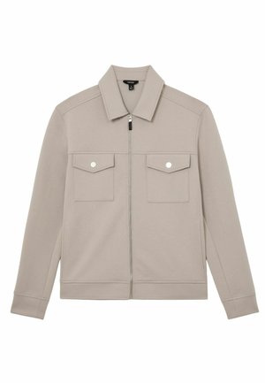 Svetlosivá bunda z mäkkej látky, s predným zipsom, špicatým golierom a dvoma náprsnými vreckami so zapínaním na cvoky.