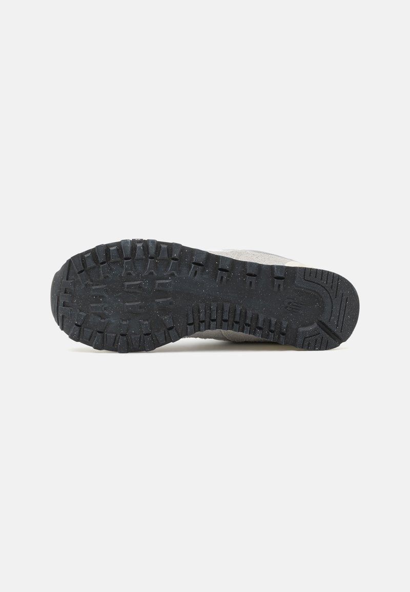 Graue Sneakersohle mit tiefen Profilen, aus Gummi. Verfügt über ein strukturiertes Muster für Halt und Stabilität. Deutlich sichtbare Logos.