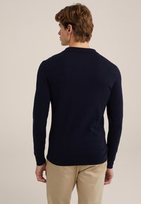 Suéter de manga larga azul marino con un clásico cuello tipo polo. El corte es ajustado y el material parece suave con una textura lisa.
