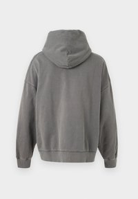 Sudadera con capucha gris que presenta una textura suave, un cuerpo ancho, hombros caídos y puños y dobladillo de canalé.