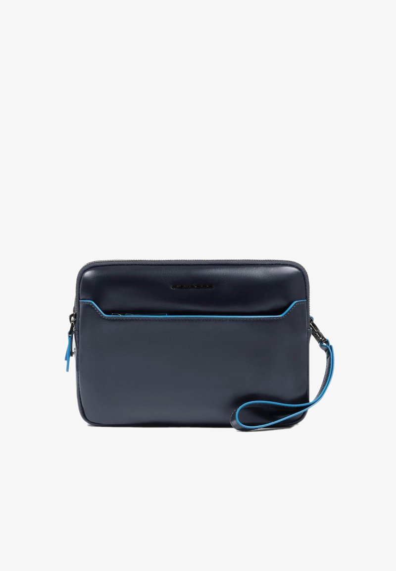 Bolsito de mano de cuero azul marino con acabado liso, que cuenta con un bolsillo delantero con cremallera y pespuntes en azul como detalle. Incluye una correa de muñeca desmontable.