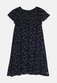 Robe bleu marine avec un col rond et des manches courtes, décorée d'un motif d'étoiles blanches, avec un détail froncé sur la poitrine et une forme fluide.