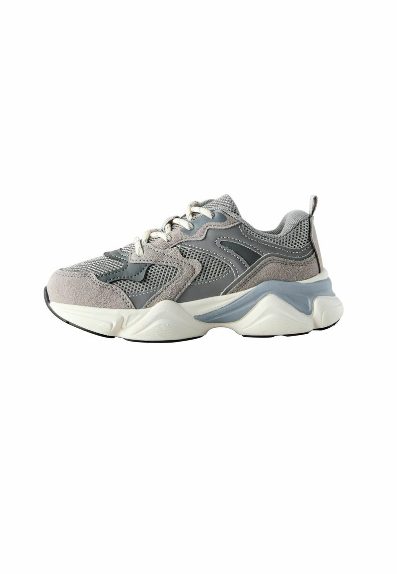 Pilkas sportinis batelis, pagamintas iš tinklelio ir zomšos medžiagų mišinys, apvalus nosis, storas baltos ir pilkos spalvos padas bei dekoratyviniai siūlės.