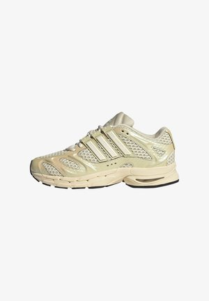 Chaussure de course beige et crème avec panneaux en mesh, trois bandes latérales, semelle coussinée et lacets, vue du côté extérieur.