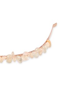 Bransoletka z różowego złota ozdobiona nieregularnymi, polerowanymi jasnymi kamieniami o różnej przezroczystości i gładkiej fakturze, nawleczonymi na cienką metalową opaskę.