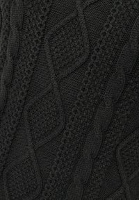 Knitted black fabric featuring textured diamond and cable patterns, with a soft, slightly raised surface and varied stitch techniques.