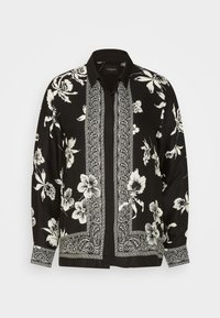 Zwarte shirt met witte bloemmotief, voorzien van een button-down kraag, lange mouwen en paisley accenten langs de voorkant en manchetten.