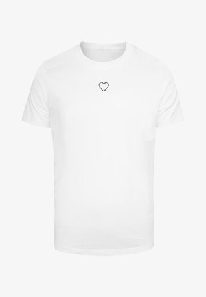 Fehér pamut póló, amelyen egy kis fekete hímzett szívminta található a mell részen. Rövid ujjú, klasszikus kerek nyakkivágással.